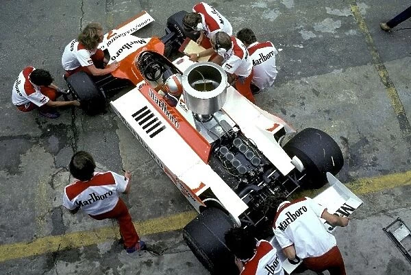 Formula One World Championship: McLaren mechanics work on the car of John Watson McLaren Cosworth M29 in the pits