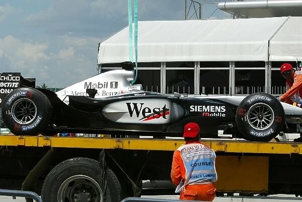 Formula One World Championship: The McLaren MP4  /  17D of David Coulthard is recovered back to the pits after his early retirement from the race