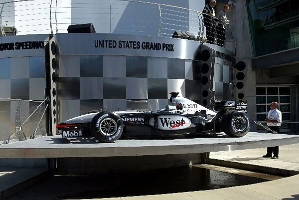 Formula One World Championship: A McLaren is used to test the car lift in front of the podium