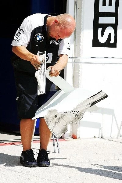 Formula One World Championship: A mechanic adds finishing toucches to Williams bodywork