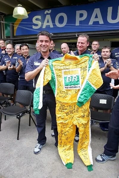 Formula One World Championship: A mechanic is presented with a signed set of overalls during the Williams Team Picture