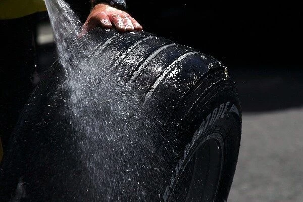 Formula One World Championship: A mechanic washes a Bridgestone tyre
