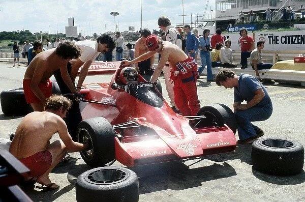 Formula One World Championship: Mechanics go about changing tyres on the radical new Brabham BT46 of third placed John Watson, which featured