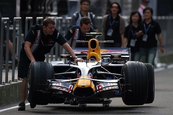Formula One World Championship: Mechanics push the car of Mark Webber Red Bull Racing RB4 down the pitlane