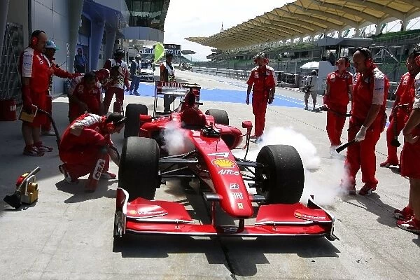 Formula One World Championship: Mechanics tend to the Ferrari F2009 of Kimi Raikkonen Ferrari stops after a possible KERS related problem