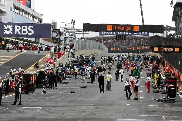 Formula One World Championship: Mechanics wait for the cars to arrive on the grid
