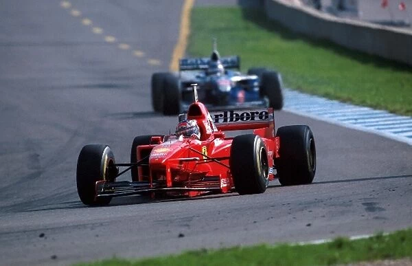 Formula One World Championship: Michael Schumacher Ferrari F310B leads Jacques Villeneuve Williams FW19