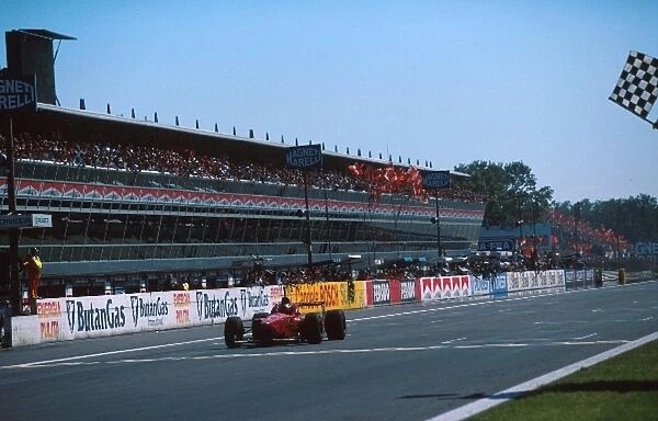 Formula One World Championship: Michael Schumacher Ferrari F310 takes the flag to the delight of the local Tifosi