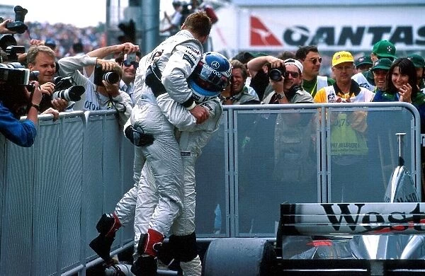 Formula One World Championship: Mika Hakkinen, McLaren MP4-13 3rd place helps David Coulthard, McLaren MP4-12 1st place to celebrate his win