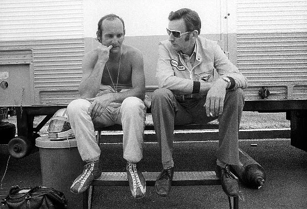 Formula One World Championship: Mike Hailwood McLaren, who crashed out of the race on lap 12, chews his nails as he talks with Phil Kerr McLaren