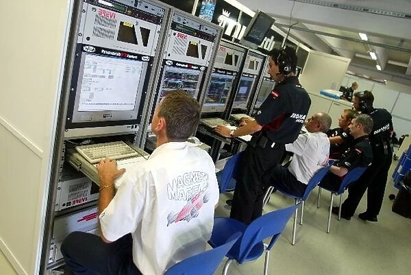 Formula One World Championship: Minardi engineers check the telemetry