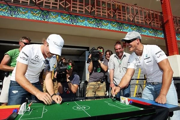 Formula One World Championship: Nico Rosberg Mercedes GP plays table football with his team mate Michael Schumacher Mercedes GP