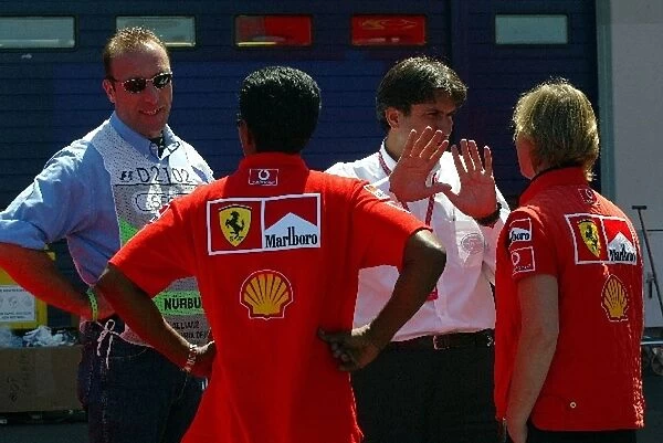 Formula One World Championship: A paddock marshal and Pasquale Lattuneddu of the FOM chat with Ferrari personnel in the paddock
