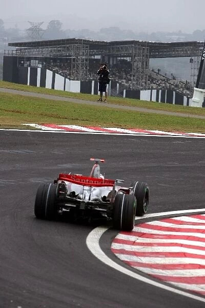 Formula One World Championship: A photographer stands in a strange position with Fernando Alonso McLaren Mercedes MP4  /  22