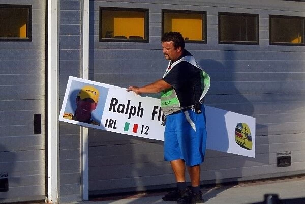 Formula One World Championship: A pitlane marshal replaces the garage name board of Ralph Firman Jnr Jordan with that of his replacement Zsolt