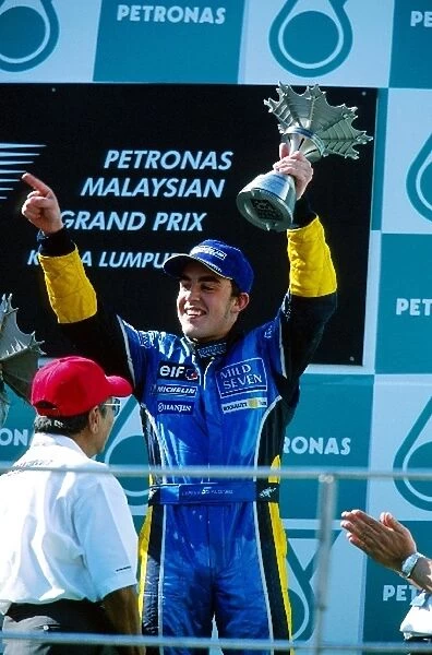 Formula One World Championship: Third placed Fernando Alonso Renault receives his and Spain├òs first podium trophy from Dr Mahathir Mohamad Malaysian