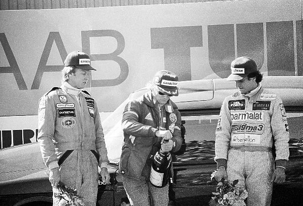Formula One World Championship: The podium against the backdrop of a SaB road car: Ronnie Peterson Lotus, third; Niki Lauda Brabham, race winner