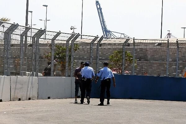 Formula One World Championship: Policemen try to convince a fan off the circuit at the start of the session