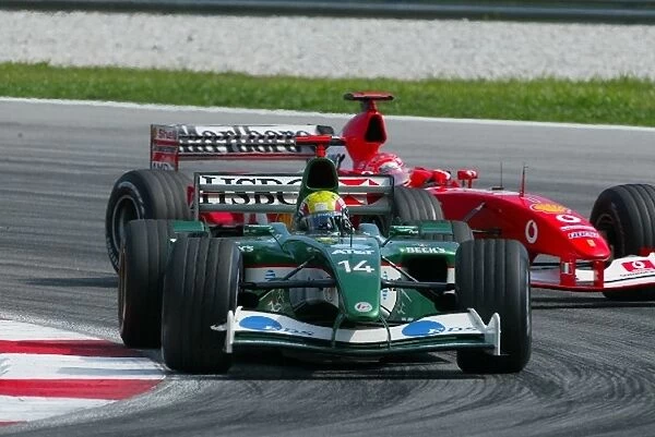 Formula One World Championship: Race retiree Mark Webber Jaguar Cosworth R4 leads sixth placed Michael Schumacher Ferrari F2002
