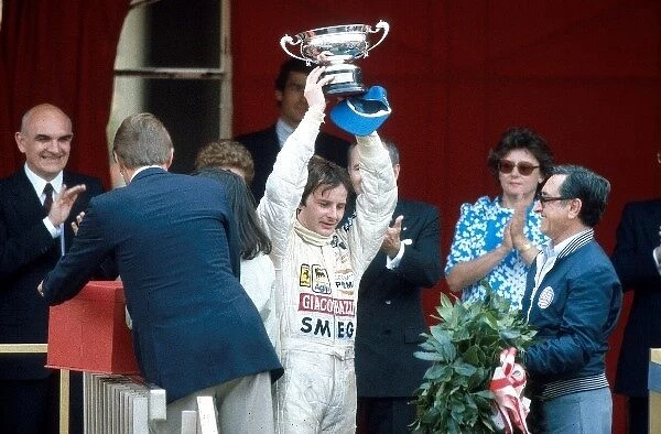 Formula One World Championship: Race winner Gilles Villeneuve Ferrari raises his trophy
