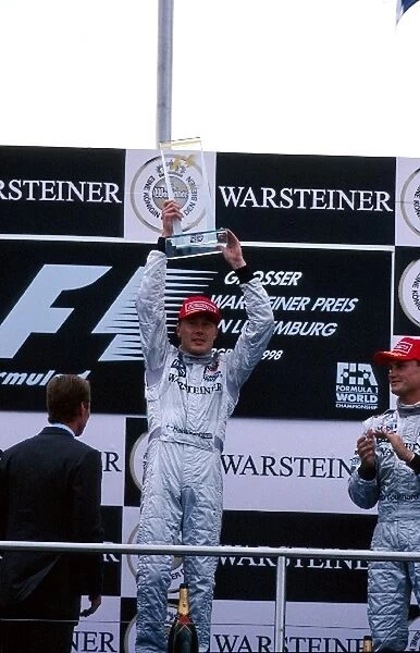 Formula One World Championship: Race winner Mika Hakkinen McLaren and David Coulthard McLaren 3rd on the podium