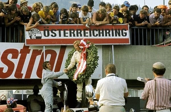 Formula One World Championship: Race winner Ronnie Peterson Lotus is congratulated on the podium by second place finisher Jackie Stewart Tyrrell