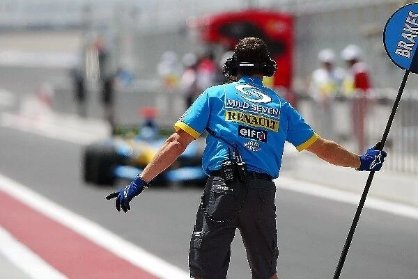 Formula One World Championship: A Renault lollipop man beckons Jarno Trulli Renault R24 into the pit box