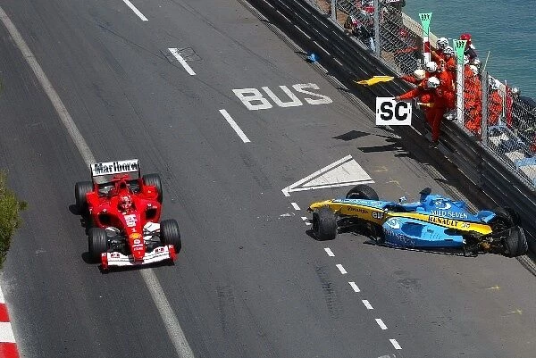 Formula One World Championship: The Renault R24 of Fernando Alonso is recovered by marshalls after crashing out of the tunnel as Michael Schumacher