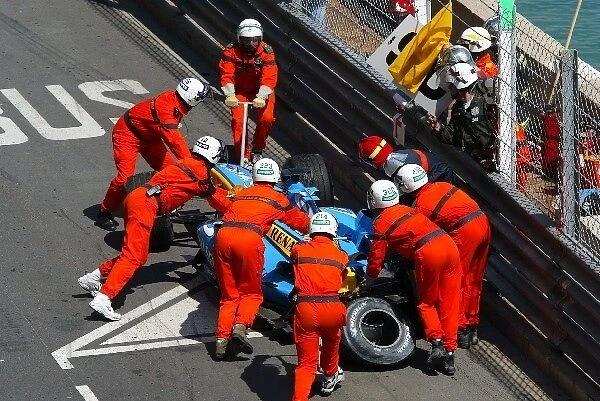 Formula One World Championship: The Renault R24 of Fernando Alonso is recovered by marshalls after crashing out of the tunnel