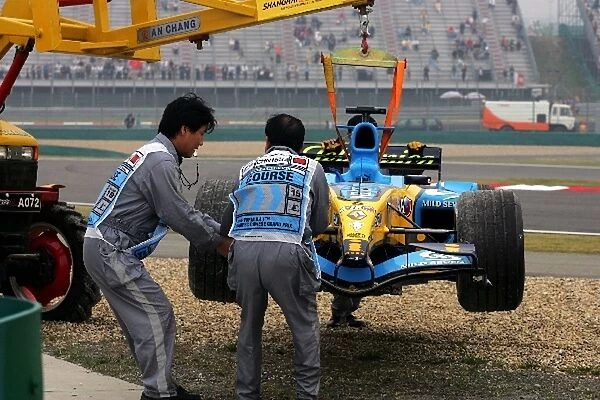 Formula One World Championship: The Renault R25 of Giancarlo Fisichella is removed after crashing out during first practice