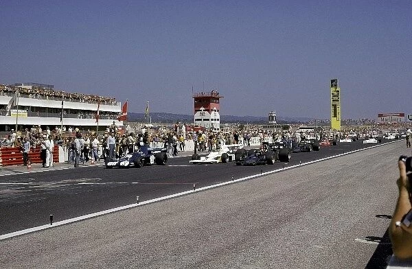 Formula One World Championship: The front row prepare to start the race: Pole sitter Jackie Stewart Tyrrell 006  /  2 who finished fourth; Jody Scheckter