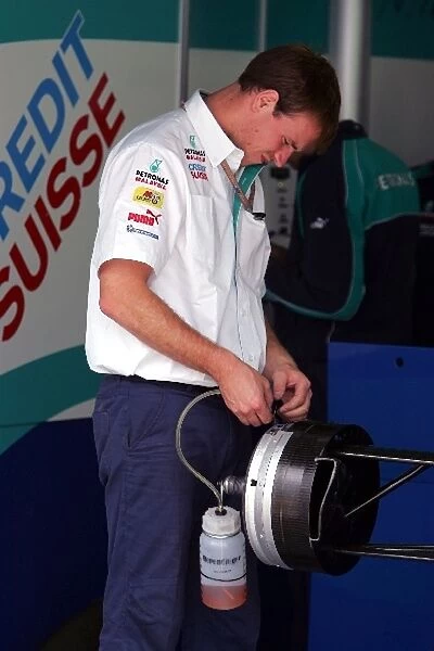 Formula One World Championship: A Sauber mechanic works on the front brakes