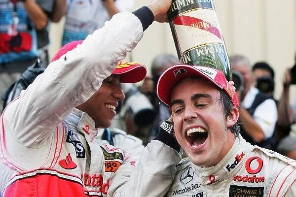 Formula One World Championship: Second place finisher Lewis Hamilton Mclaren and race winner Fernando Alonso McLaren celebrate with the champagne