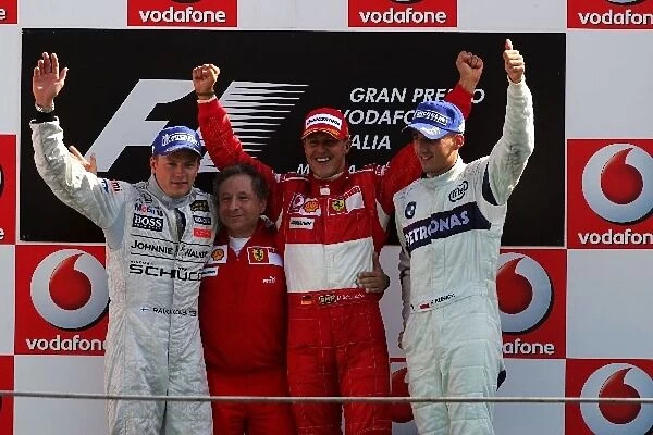 Formula One World Championship: Second place Kimi Raikkonen McLaren, Jean Todt Ferrari Sporting Director, race winner Michael Schumacher Ferrari