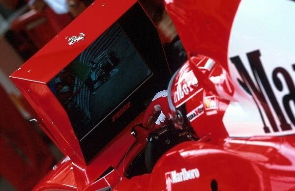 Formula One World Championship: Second placed finisher Michael Schumacher Ferrari F2002 watches Eddie Irvine Jaguar R3 crash into the barriers