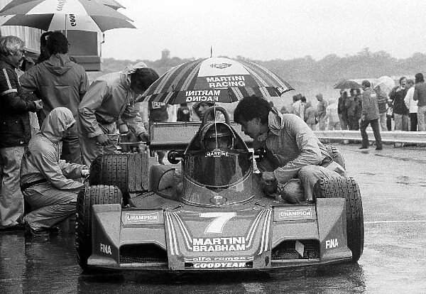 Formula One World Championship: Sixth placed John Watson Brabham BT45, sits in a wet pit lane talking with Gordon Murray Brabham Designer