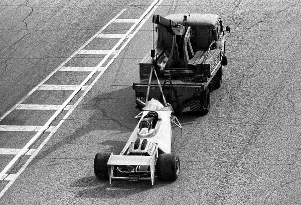 Formula One World Championship: The Surtees TS20 of Vittorio Brambilla is taken away from the scene of the massive start accident which left