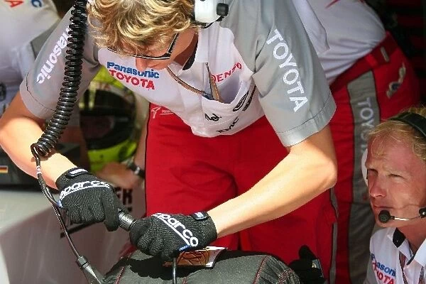 Formula One World Championship: A Toyota engineer works with the tyre warmers