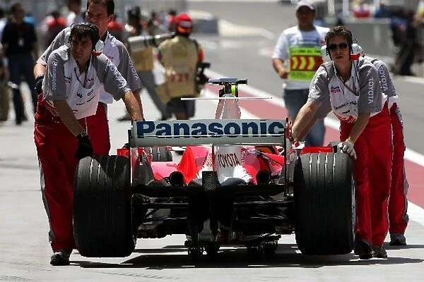 Formula One World Championship: Toyota mechanics push back the Toyota TF105 of Ralf Schumacher