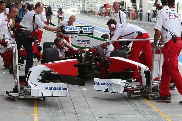 Formula One World Championship: Toyota practice a front wing change in the first practice session