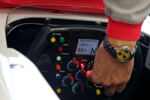 Formula One World Championship: Toyota steering wheel buttons are adjusted by a mechanic