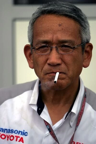 Formula One World Championship: Tsutomu Tomita Chairman of Toyota Racing and Toyota Team Principal smokes a cigarette