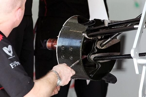 Formula One World Championship: Virgin Racing VR-01 brake is worked on by a mechanic