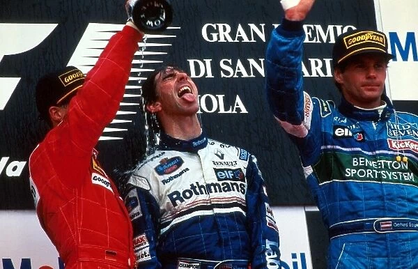 Formula One World Championship: Winner Damon Hill Williams FW18 gets a mouthful of champagne from Michael Schumacher as Berger 3rd waves to the crowd