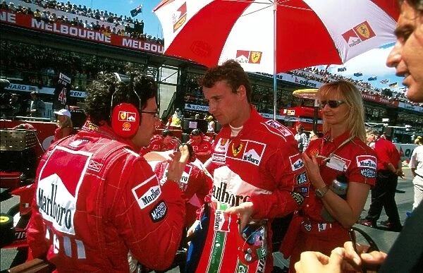 Formula One World Championship: Winner Eddie Irvine Ferrari F199 on the grid before the start, sister Sonia holding umbrella