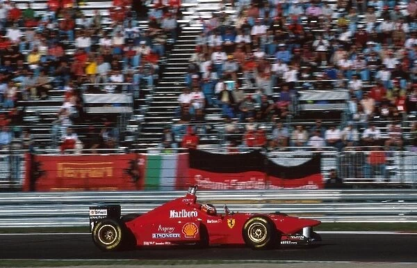 Formula One World Championship: Winner Michael Schumacher Ferrari F310 raises his hand acknowledging the support of the Ferrari fans