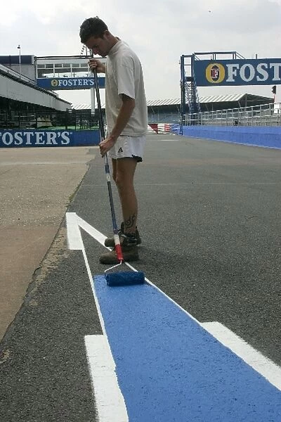 Formula One World Championship: A worker paints the pit lane