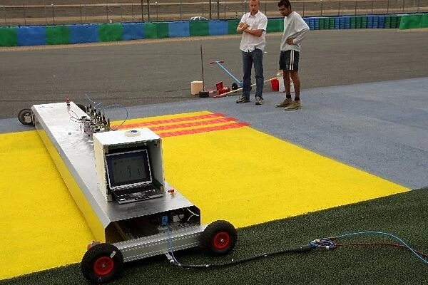 Formula One World Championship: Workers paint advertising on the run off areas