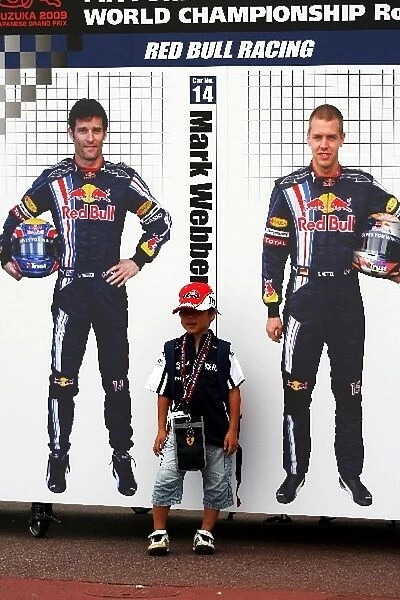 Formula One World Championship: Young child with pictures of Mark Webber Red Bull Racing and Sebastian Vettel Red Bull Racing