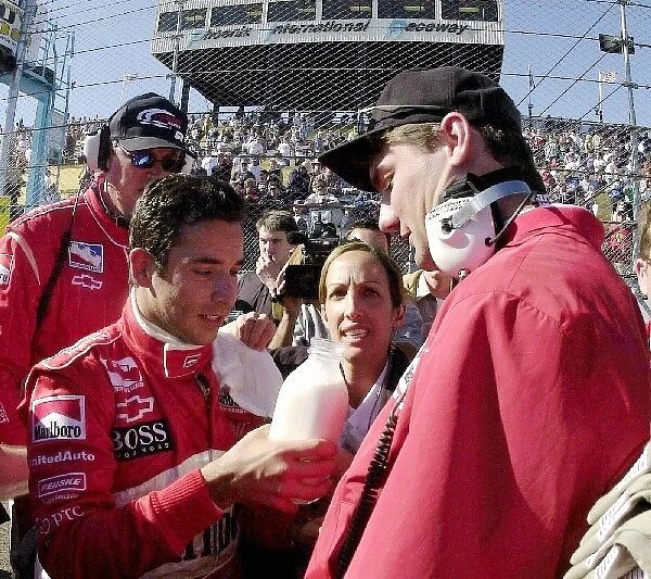 Helio Castroneves, (BRA), hands the victory milk bottle to Marlboro Team Penske team manager Tim Cindric after the finish of the Copper World 200. Phoenix, Az. March